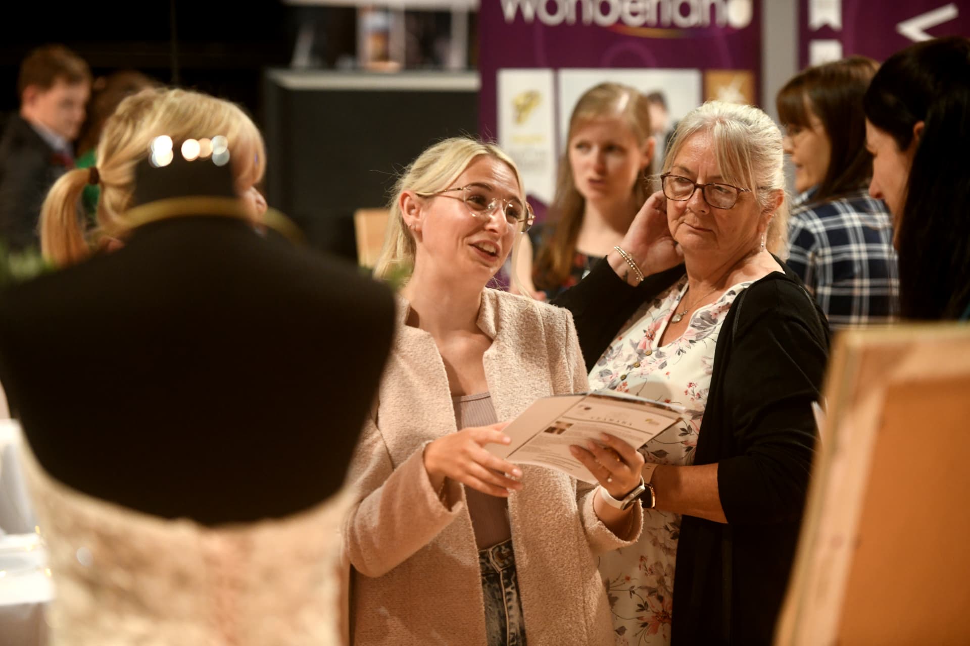 Two visitors reading an exhibitor brochure at the fair