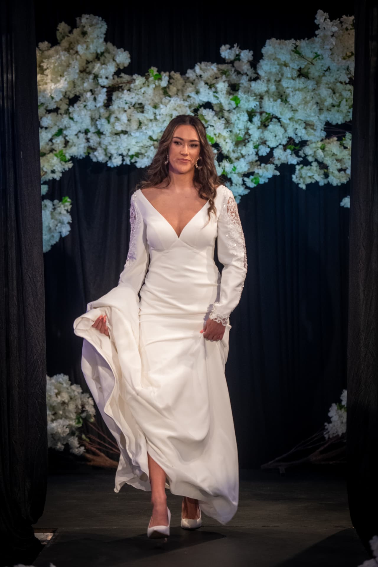 Model walking the bridal catwalk in a satin wedding gown