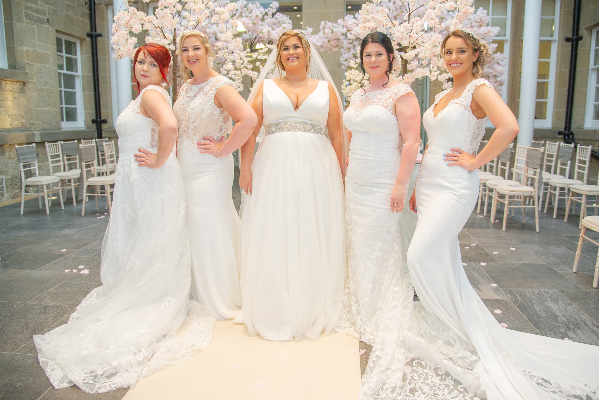 Five models in wedding gowns posing in the Alexander Graham Bell Centre atrium