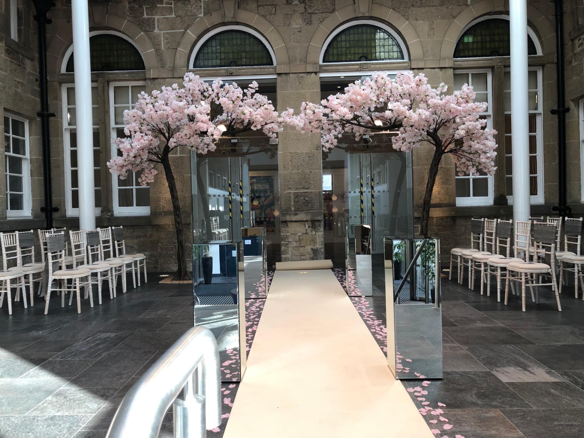 Catwalk aisle lined with blossom trees and petals at Moray College UHI, Elgin