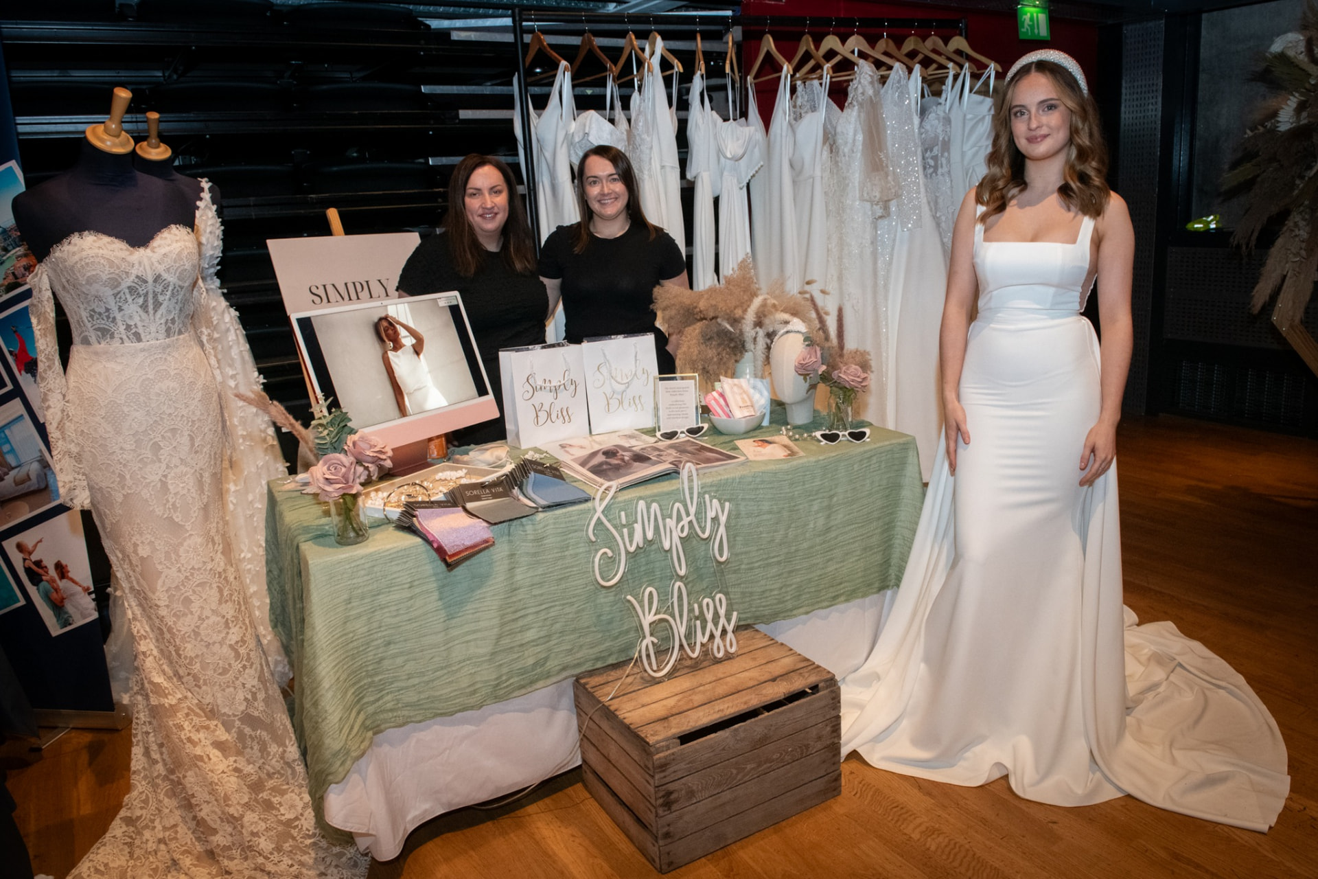 Bridal boutique stand with gowns on display and a model in a white dress
